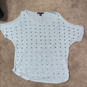 Grey t-shirt with studs, open shoulders.